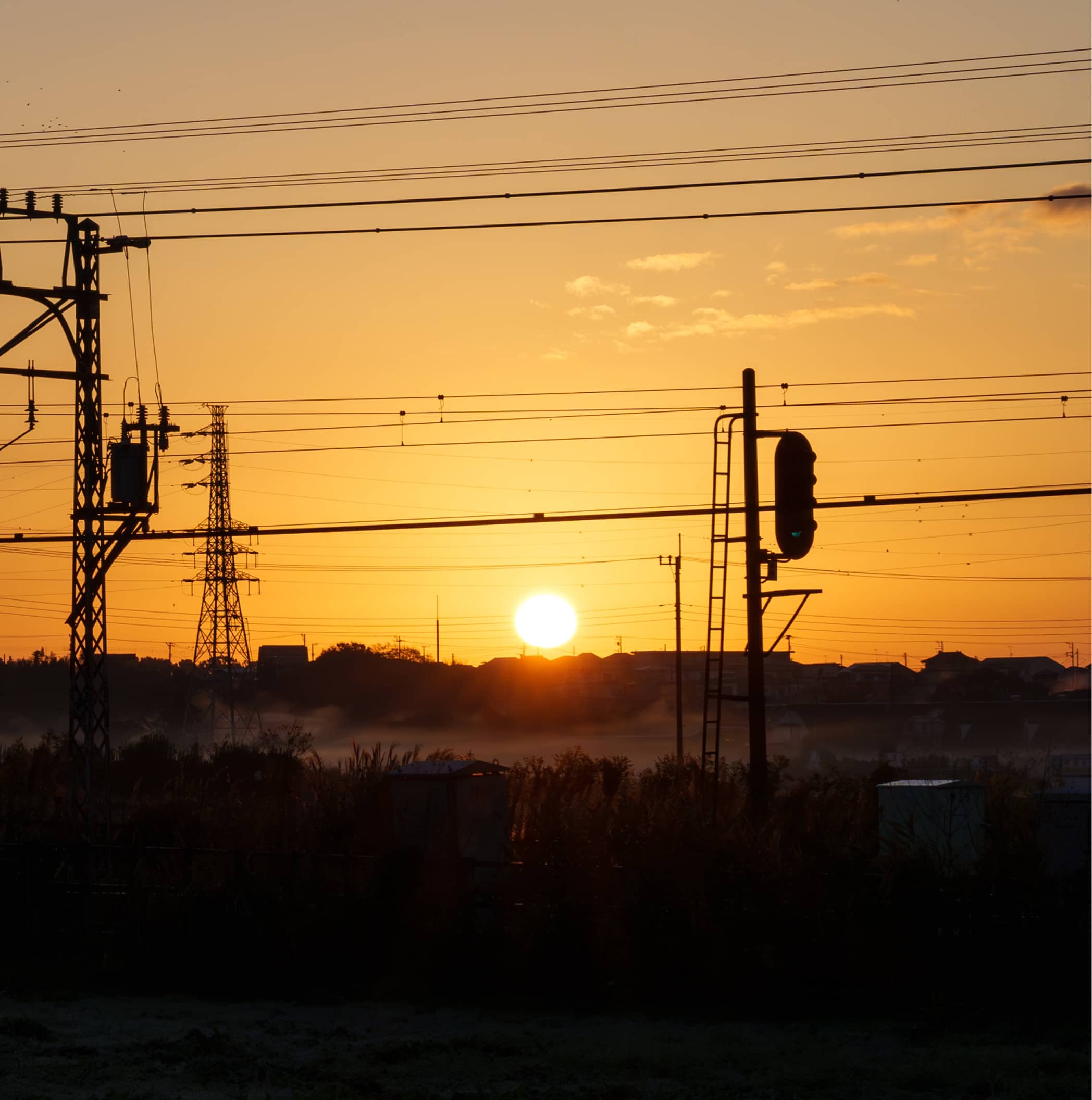 夕日に照らされた鉄道設備と信号機